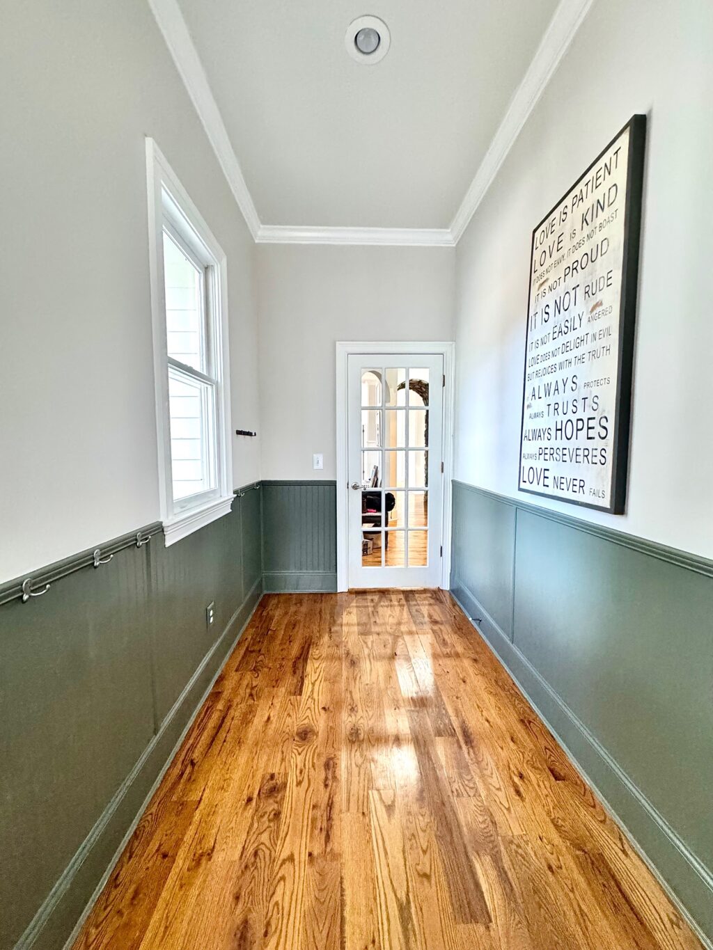 hallway with green walls and wood floor