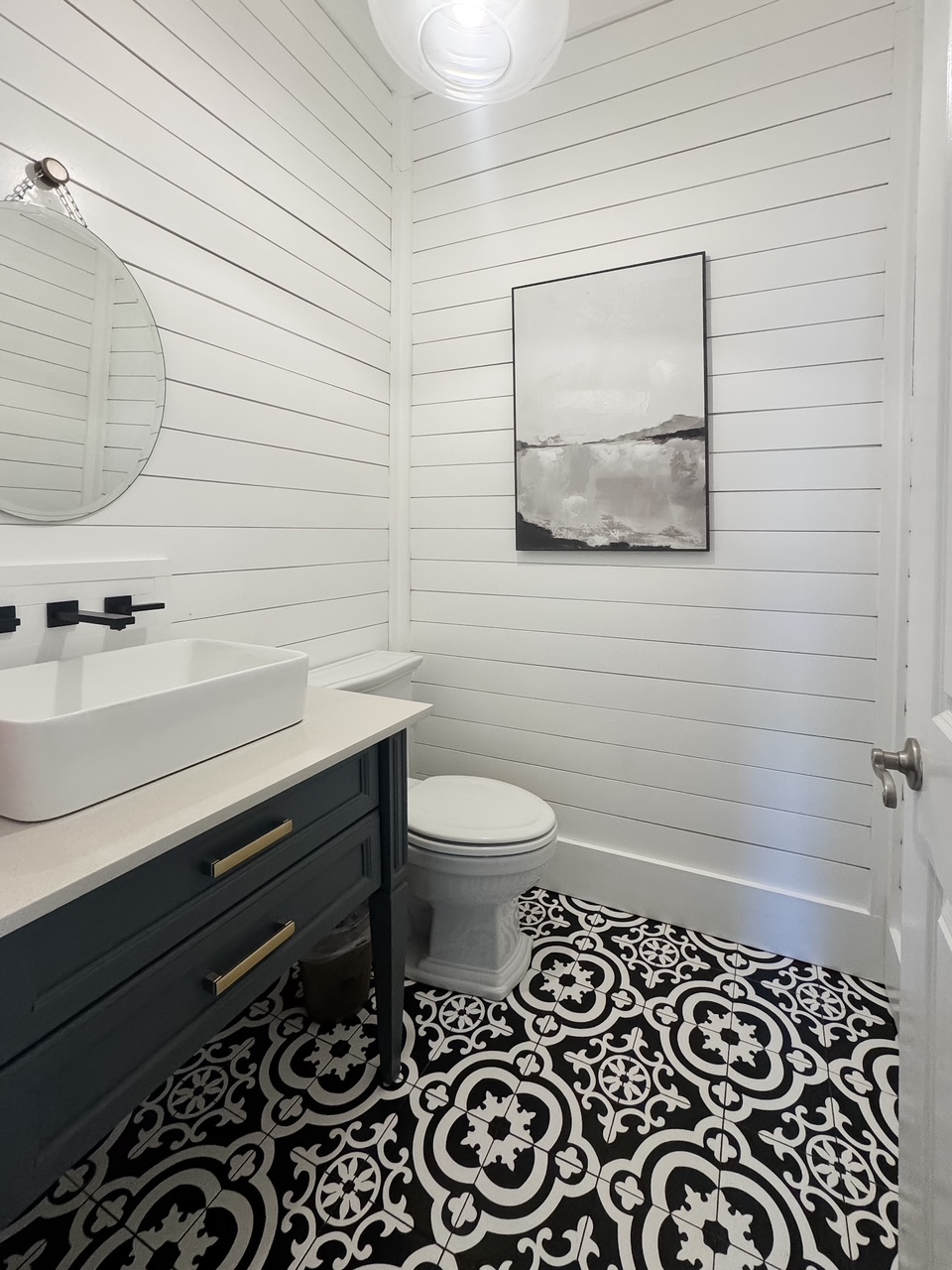 black and white guest bathroom with wall mounted faucet