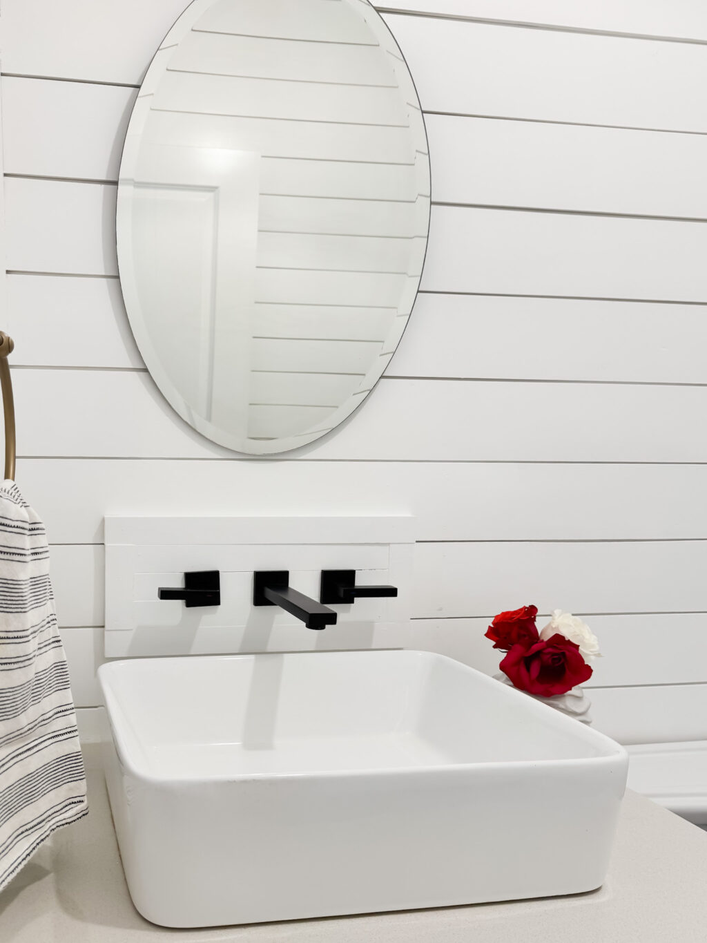 wall mounted faucet on a white wood planked wall