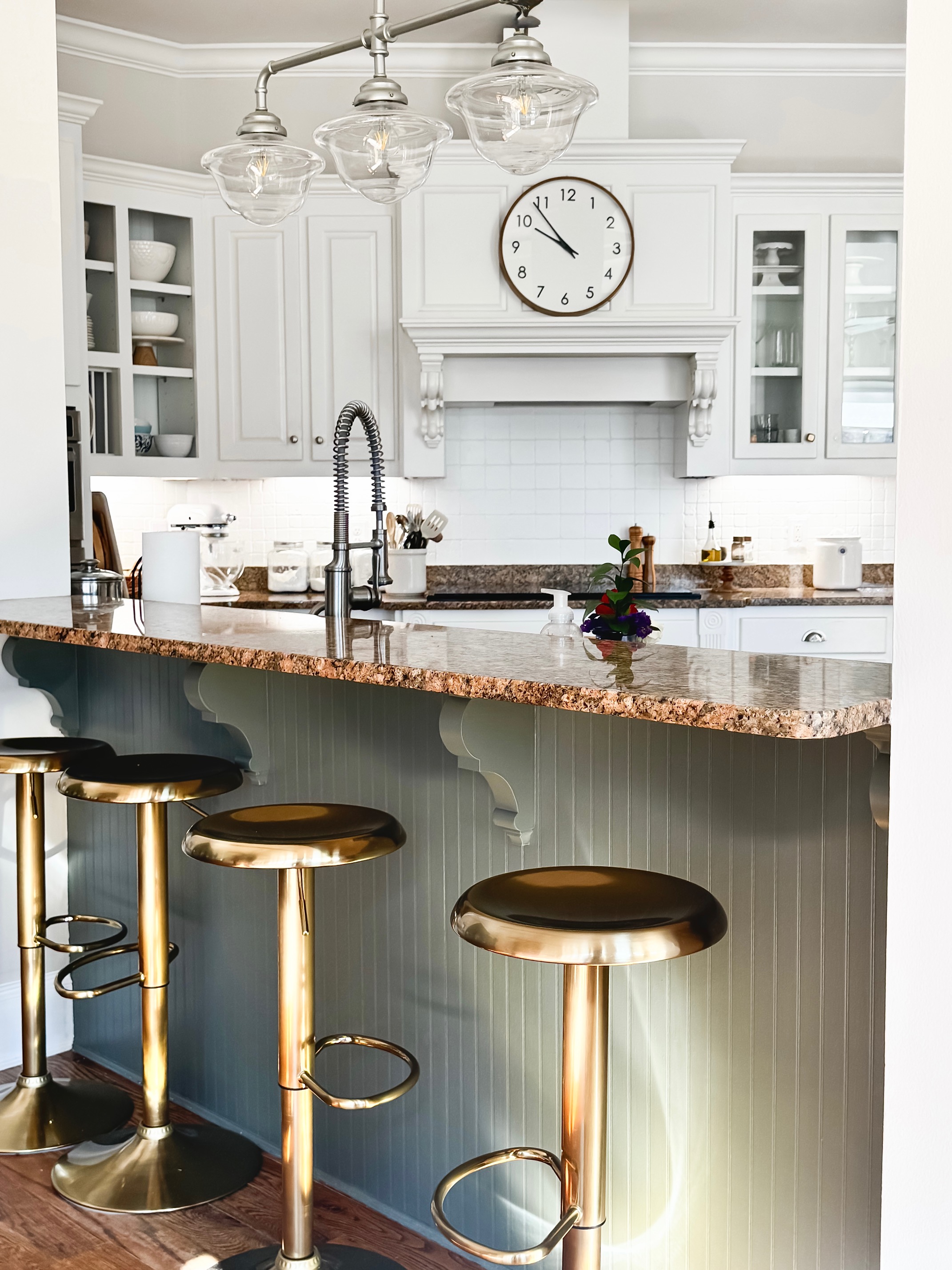 brass stools in front of SW Thunderous color kitchen island